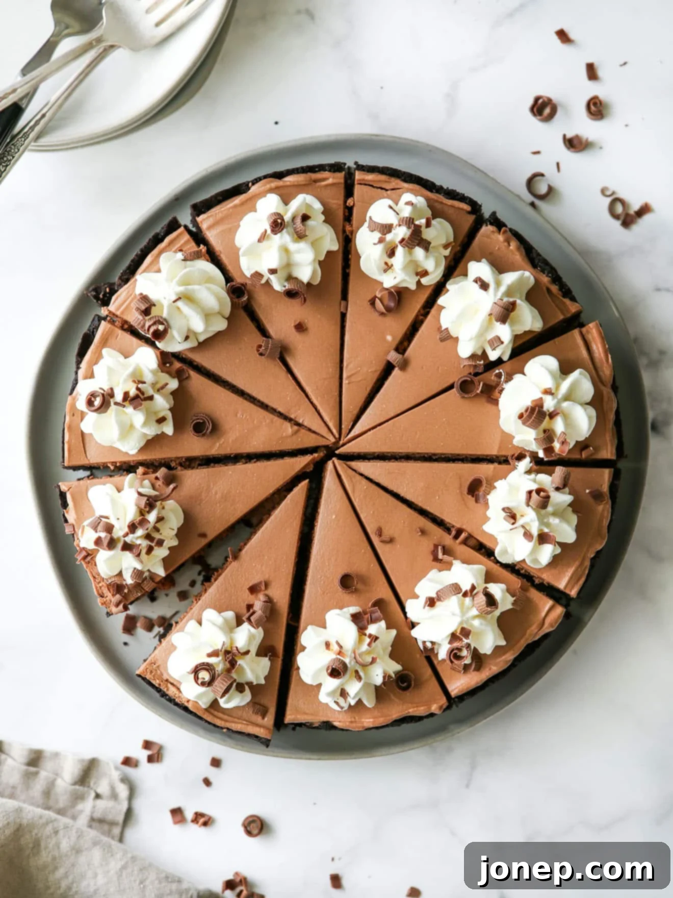 A beautifully sliced no-bake chocolate cheesecake, garnished and ready to serve.