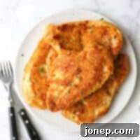 Crispy Baked Chicken 11 oven fried chicken piled on a plate with chives