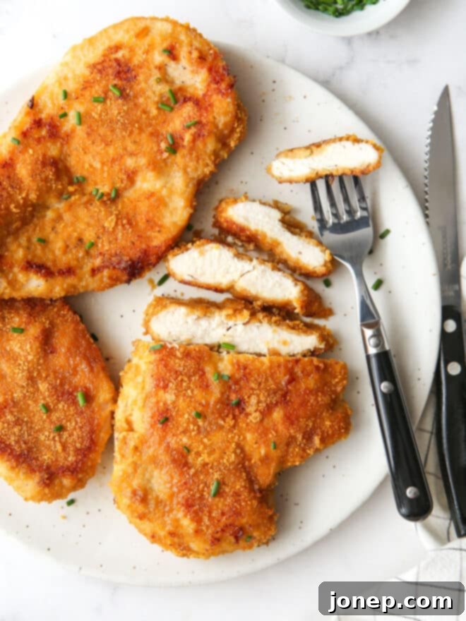 Crispy Baked Chicken 10 plate of oven fried chicken with slices and a fork and knife