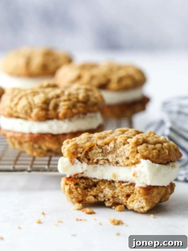 Dreamy Oatmeal Cream Pie Cookies 3 A single oatmeal cream pie with a bite taken out, revealing the creamy filling and chewy cookie layers.