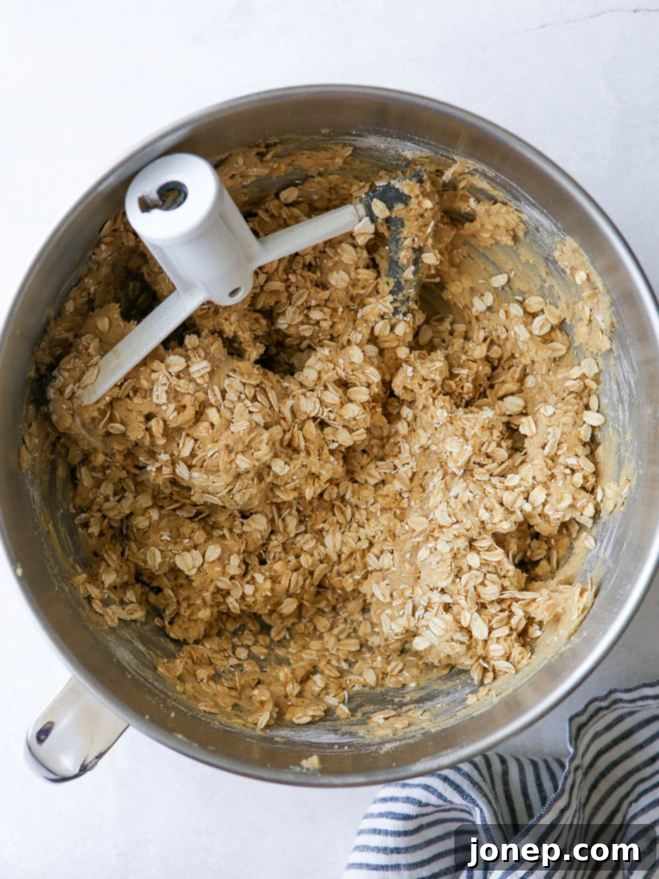 Oatmeal cookie dough in a mixing bowl, ready for scooping.