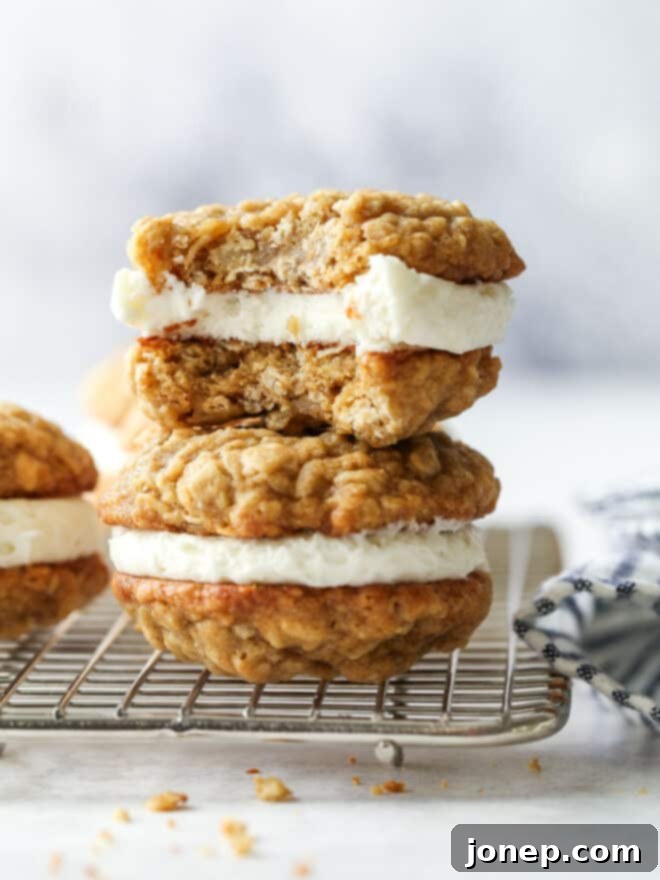 Dreamy Oatmeal Cream Pie Cookies 9 A small stack of oatmeal cream pie cookies, with one cookie showing a bite taken out, revealing the filling.