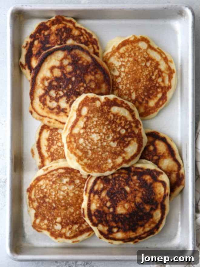 A close-up of a perfectly cooked buttermilk pancake, golden brown and ready for toppings.