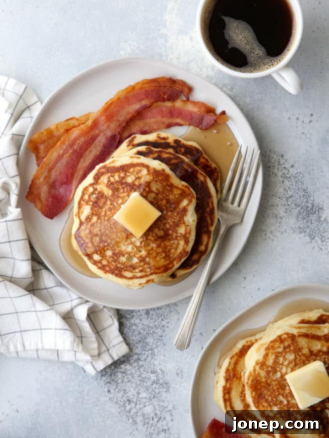 A close-up of a stack of fluffy buttermilk pancakes, ready to be topped and enjoyed for a perfect breakfast.