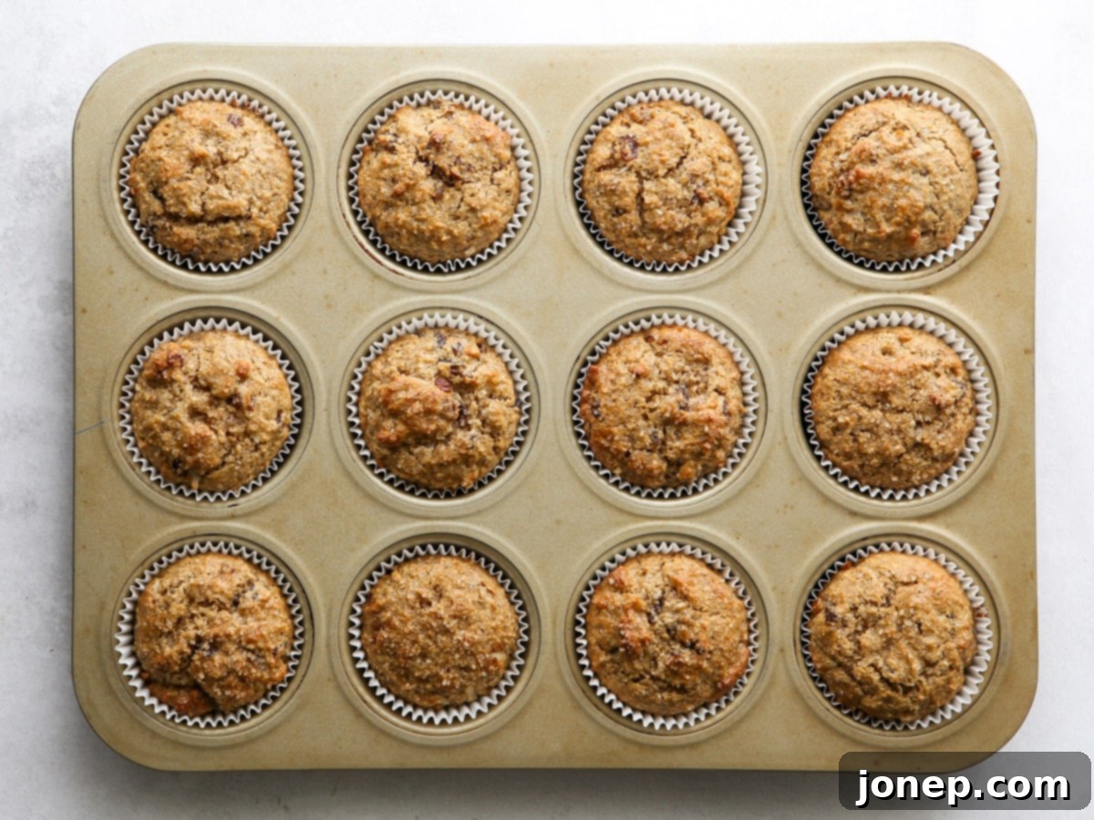 Freshly baked golden brown bran muffins cooling in a muffin pan