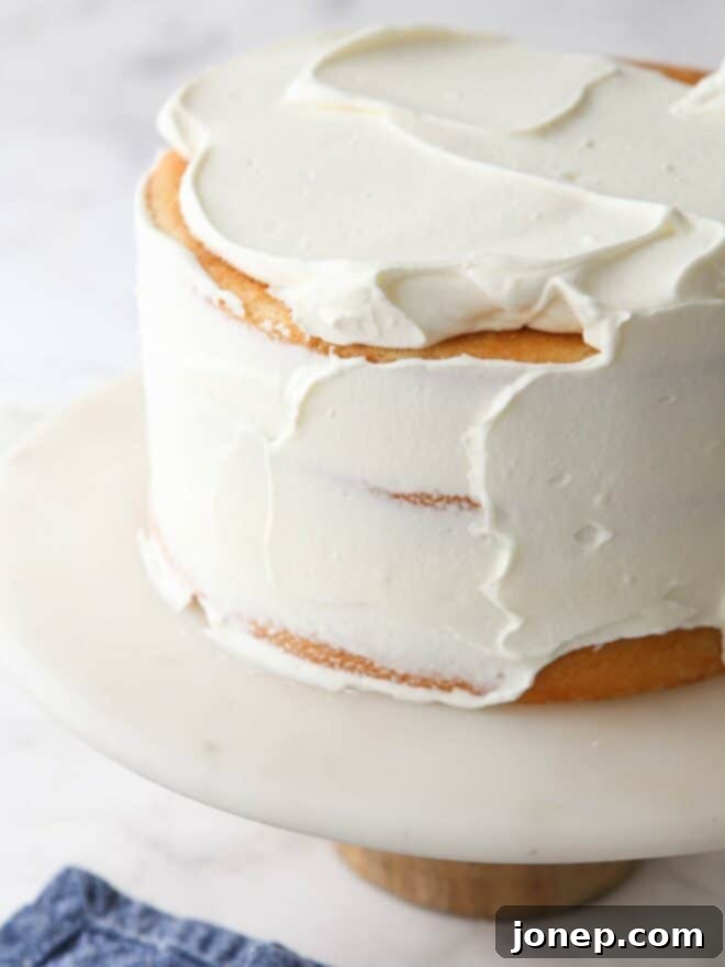 Spreading smooth Chantilly cream frosting on a freshly baked cake