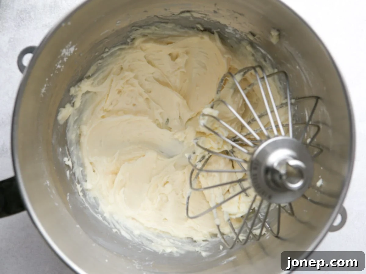 Whisking softened cream cheese, powdered sugar, vanilla extract, and salt together in a mixing bowl