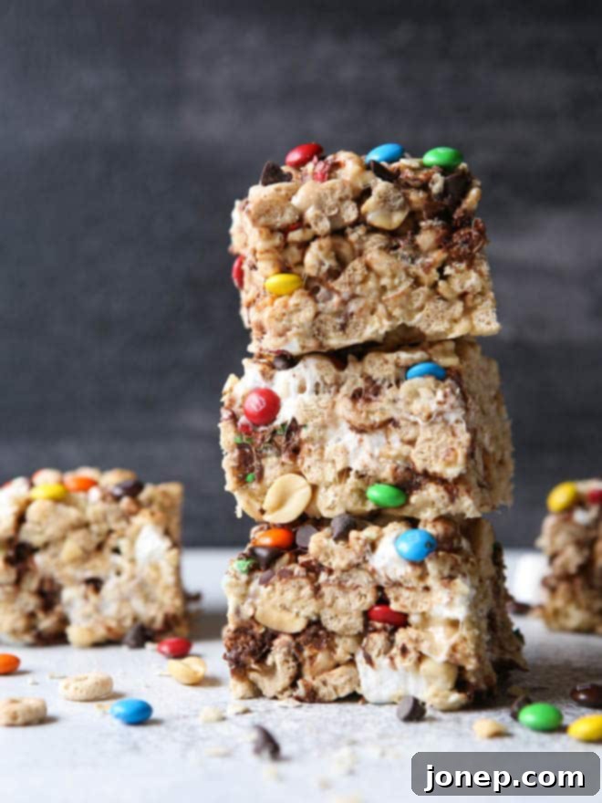 15 Effortless No-Bake Delights 3 Monster Marshmallow Cereal Treats from completelydelicious.com, packed with colorful candies and chocolate chips.