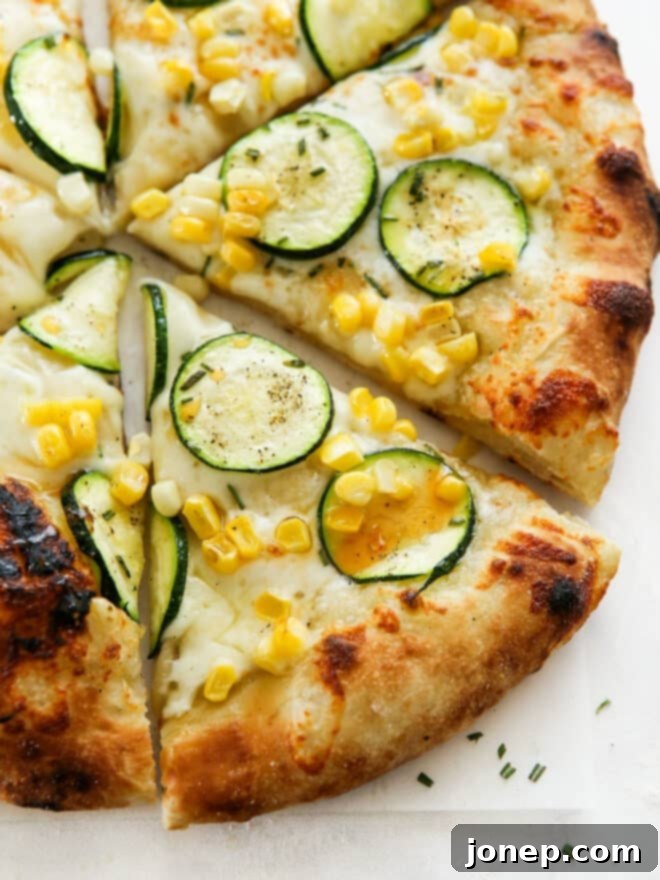 Sweet Corn and Zucchini Pizza 2 Close-up of zucchini corn pizza with a drizzle of hot honey on it, showcasing fresh ingredients