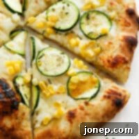 Sweet Corn and Zucchini Pizza 9 close up of zucchini pizza with a drizzle of hot honey on it