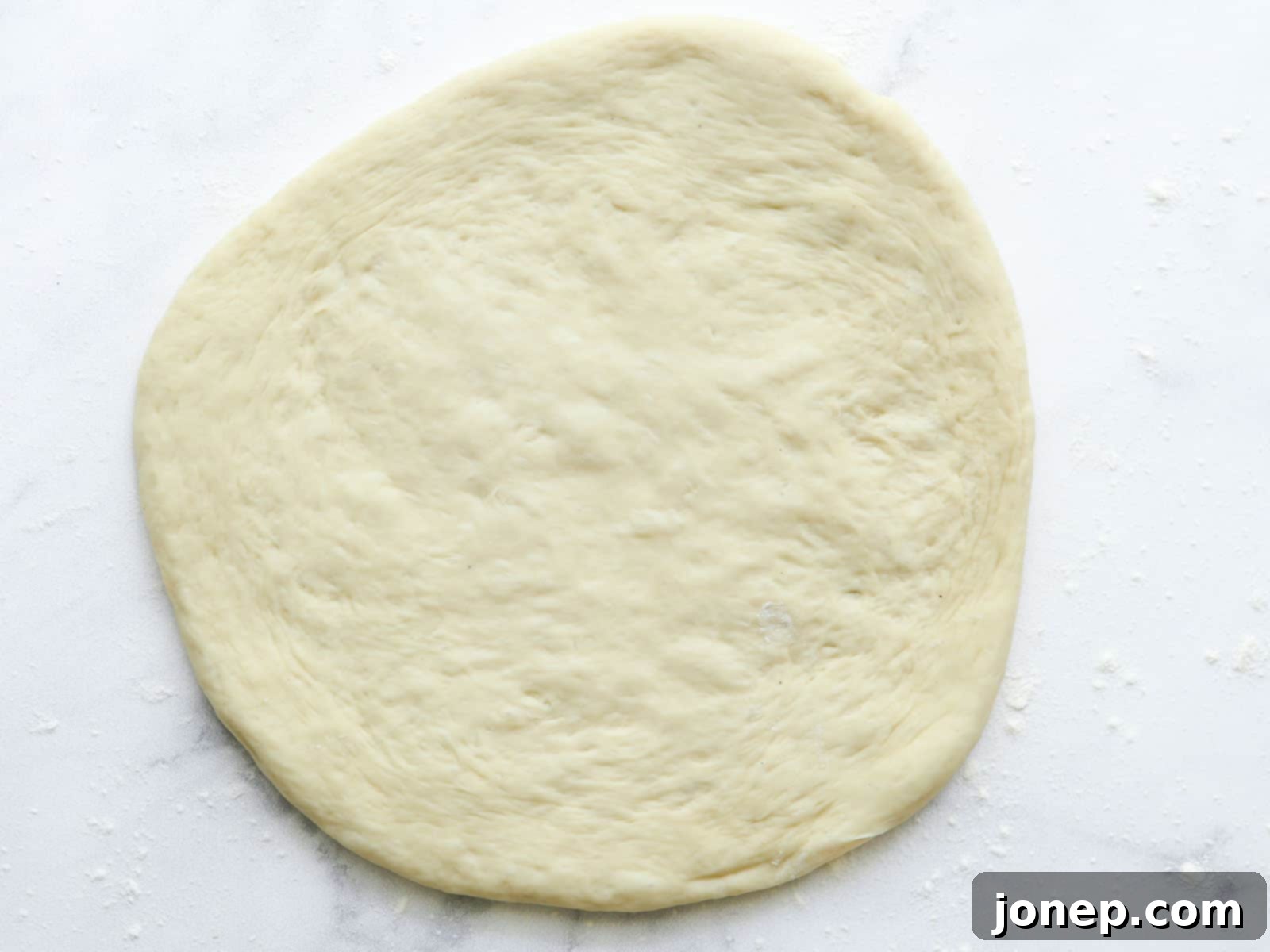 rolled out pizza dough on counter