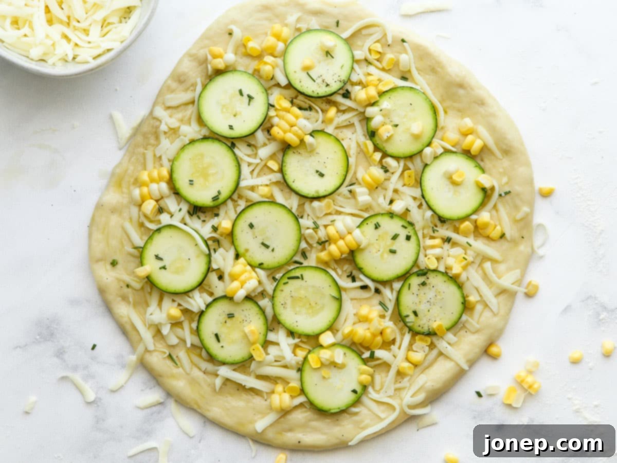 assembled zucchini corn pizza ready for the oven