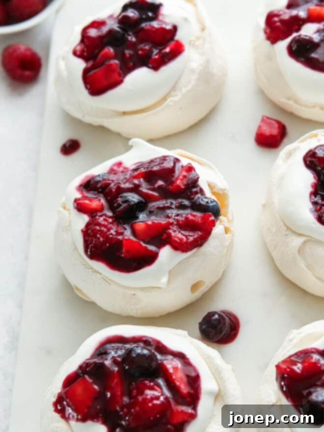 Sweet Berry Medley 2 Fresh berry compote on top of pavlovas and whipped cream, ready to be served as a delightful dessert.