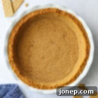 Close-up of a perfectly baked graham cracker crust in a pie pan.