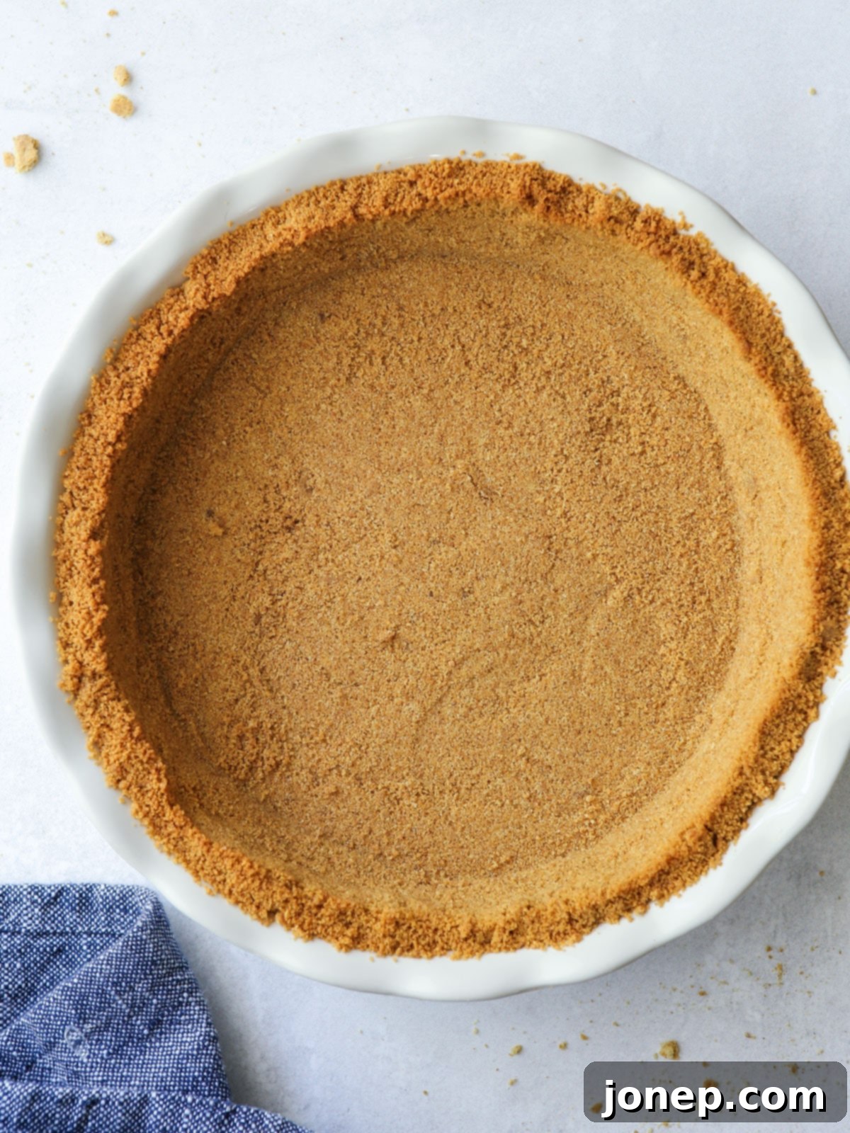 Freshly baked graham cracker crust in a pie pan, cooled and ready for filling.