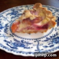 Tangy Crème Fraîche Peach Pie 2 A slice of Peach and Crème Fraîche Pie, showing the fruit and creamy filling, next to a full pie.