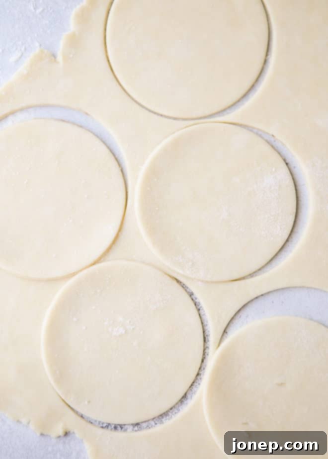 Several mini sour cream apple pies arranged on a cooling rack, freshly baked.