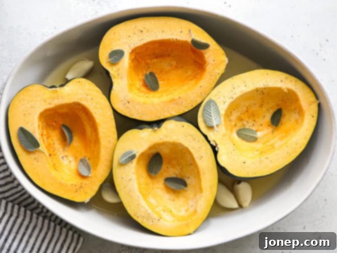 Golden Roasted Acorn Squash with Velvety Sage Cream 5 Acorn squash halves, seasoned and ready for roasting, nestled in a baking dish with broth, sage, and whole garlic cloves.