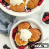 Rustic Berry Cobbler 8 Warm, scooped mixed berry cobbler in a serving dish, topped with a melting scoop of vanilla ice cream.