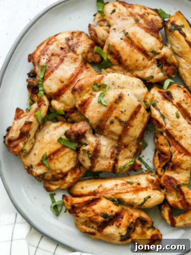grilled chicken with basil garnish on a plate