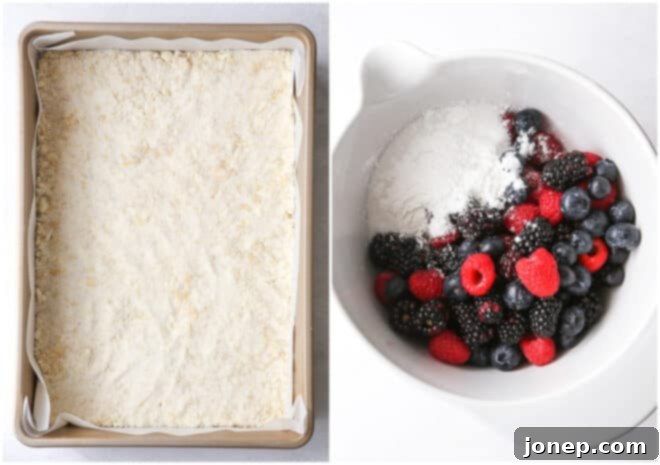image showing a baking pan with pressed crumb crust and a bowl of mixed berry filling ingredients
