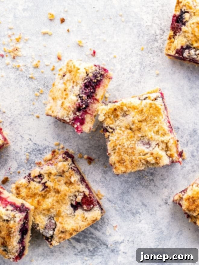 multiple berry crumb bars scattered on a wooden board