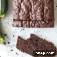 Decadent Chocolate Zucchini Bread 8 bite taken out of a slice of chocolate zucchini bread