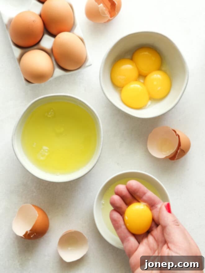 Why Room Temperature Eggs Matter in Baking 2 A close-up image of hands gently separating egg whites from yolks, emphasizing the delicate nature of eggs in baking.