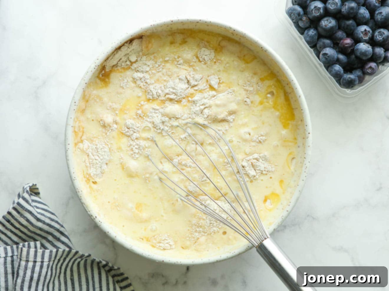 Whisking wet ingredients (buttermilk, eggs, melted butter, vanilla) in a bowl