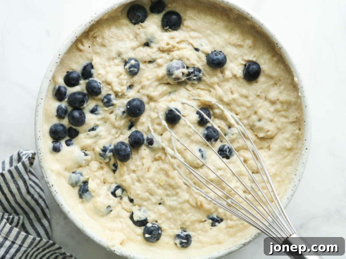 Folding fresh blueberries into pancake batter with a spatula