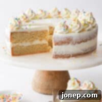 A tempting slice of sugar cookie layer cake, showing fluffy frosting and tender cookie layers, ready to be enjoyed.