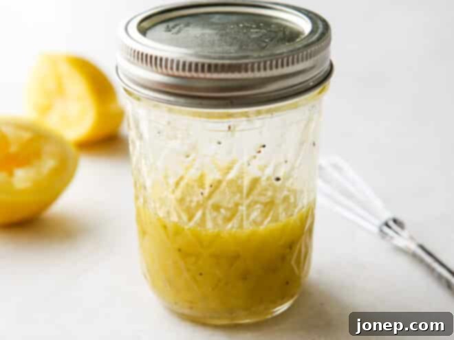Homemade lemon parmesan vinaigrette mixed in a glass jar with a metal lid, ready to be used