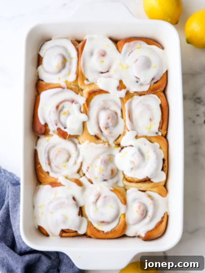 Zesty Lemon Cinnamon Rolls 2 Glazed lemon cinnamon rolls in a baking pan, fresh from the oven, with a bright, inviting appearance.