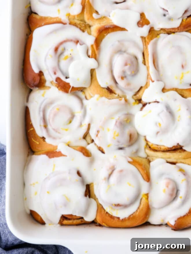 Zesty Lemon Cinnamon Rolls 7 Close-up of glazed lemon cinnamon rolls in a pan, highlighting the glossy glaze and soft texture.