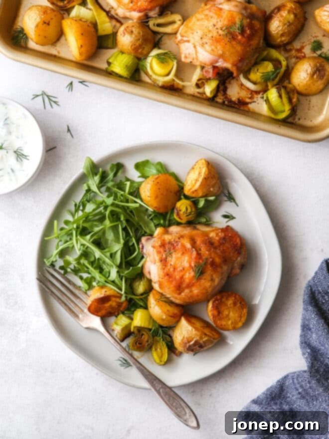 Sheet Pan Chicken, Potatoes & Leeks Dinner 3 Close-up of roasted chicken thighs, potatoes, and leeks on a sheet pan