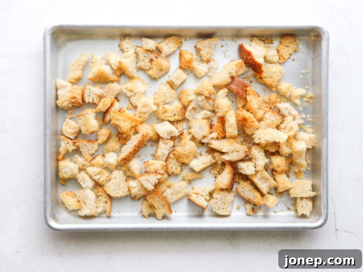 Golden-brown, perfectly toasted homemade croutons on a sheet pan, ready for the Chicken Caesar Pasta Salad.