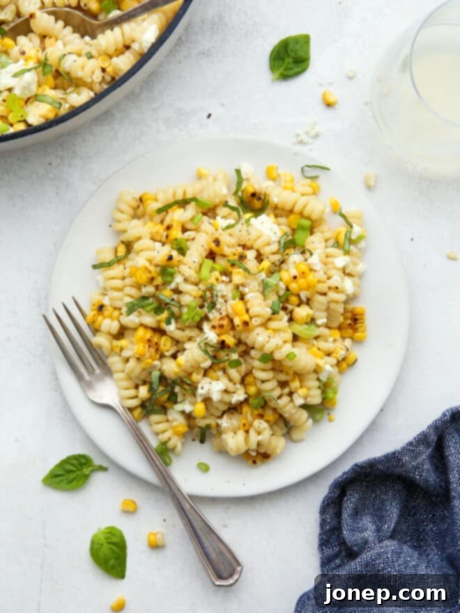 Smoky Creamy Grilled Corn Pasta 3 A full plate of creamy grilled corn pasta, artfully arranged with fresh basil and feta crumbles