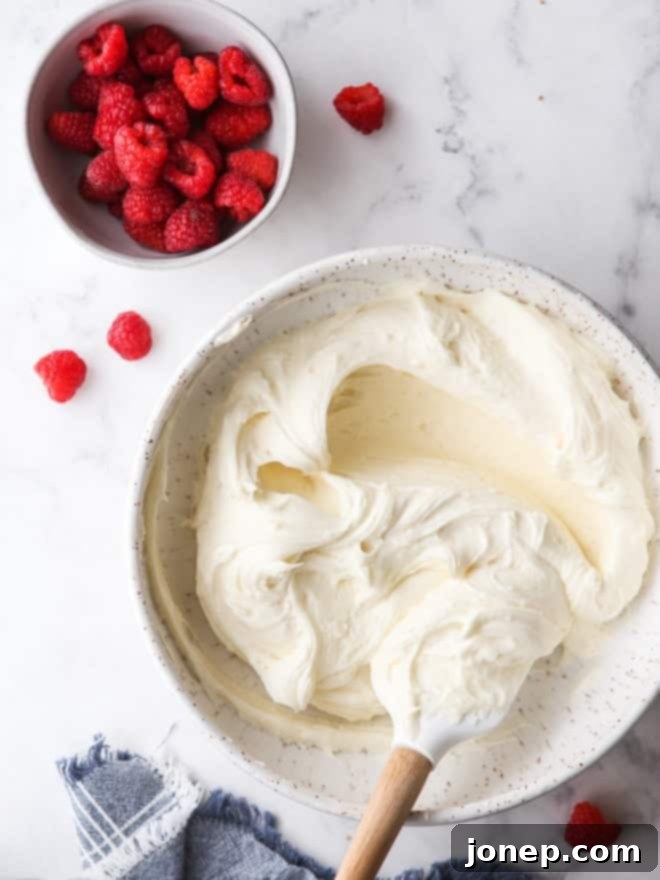 white chocolate buttercream frosting and a bowl of raspberries