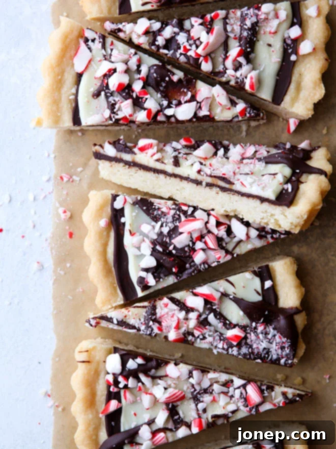 Beautifully arranged Peppermint Bark Shortbread Cookies on a white plate, showcasing the chocolate layers and crushed candy cane topping.