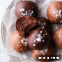 a salted chocolate truffle with a bite taken out, on a small plate
