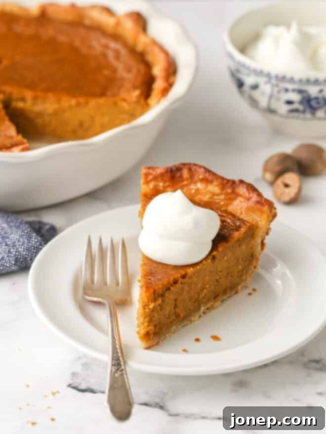 A beautifully baked classic pumpkin pie with a golden, crimped crust, resting on a wooden board, ready for slicing.