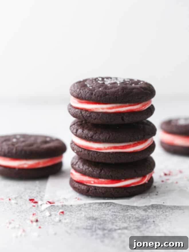 A stack of delightful chocolate candy cane sugar cookies, showcasing their vibrant red and white peppermint frosting