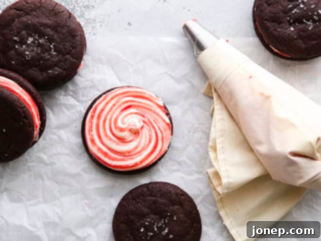piping candy cane frosting onto a chocolate cookie