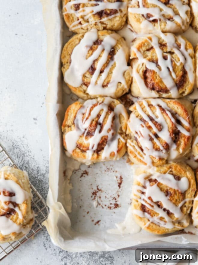 Sweet Cinnamon Swirl Biscuits 8 baked cinnamon roll biscuits in a pan with one missing, showing it was just taken out