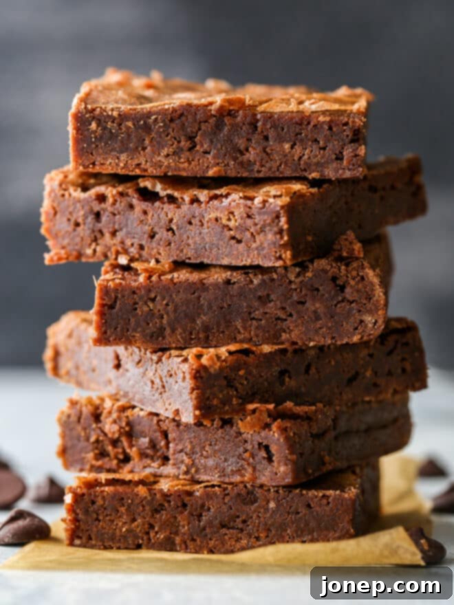 stack of classic fudge brownies with a shiny crackly crust