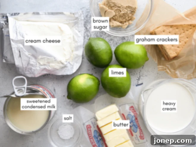 Key Lime No-Bake Cheesecake Bars 3 A collection of ingredients laid out on a table, including limes, cream cheese, and graham crackers, ready for making cheesecake bars.