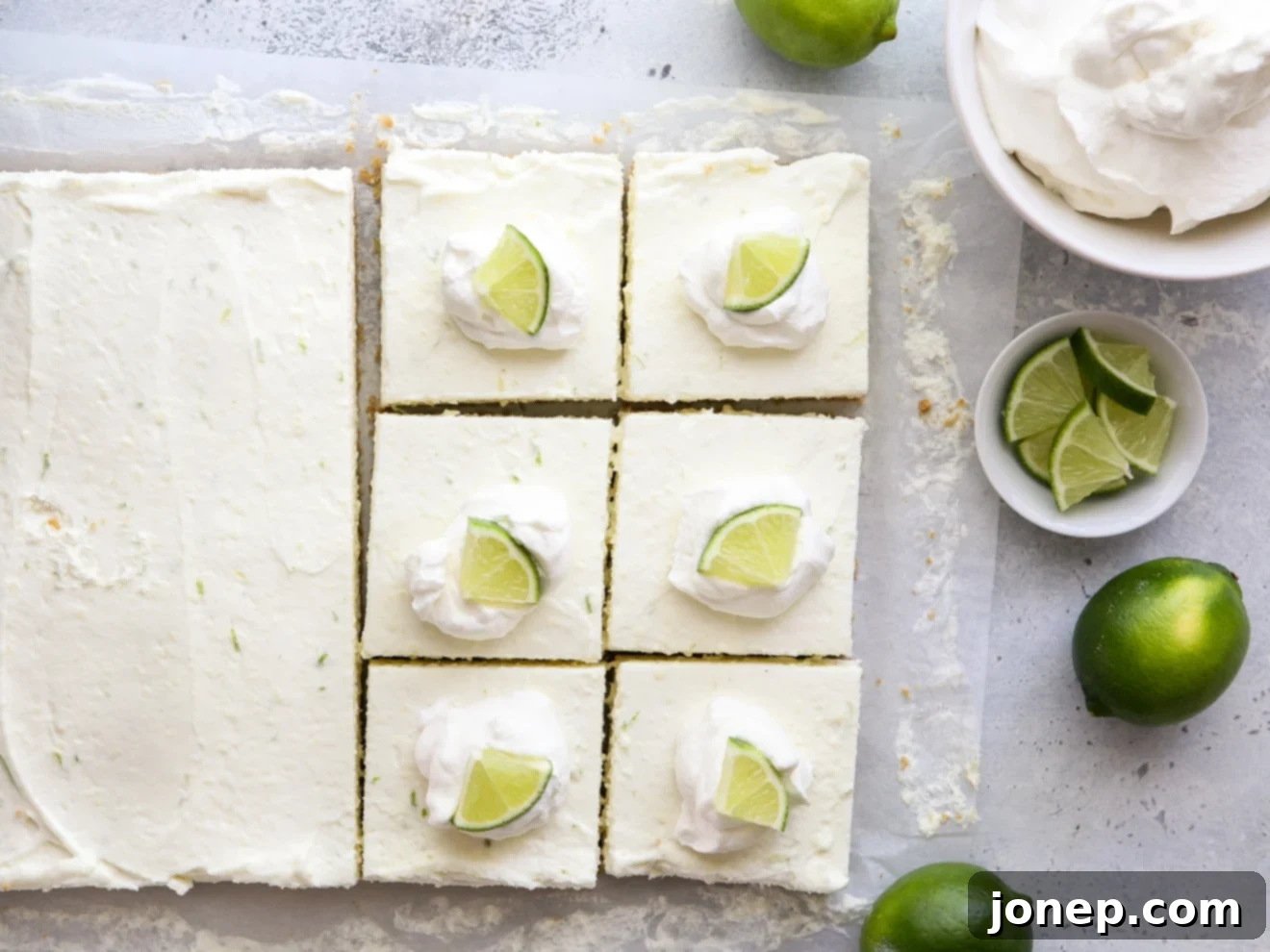A pan filled with no-bake lime cheesecake bars, perfectly chilled and ready for slicing, showing the smooth top layer.