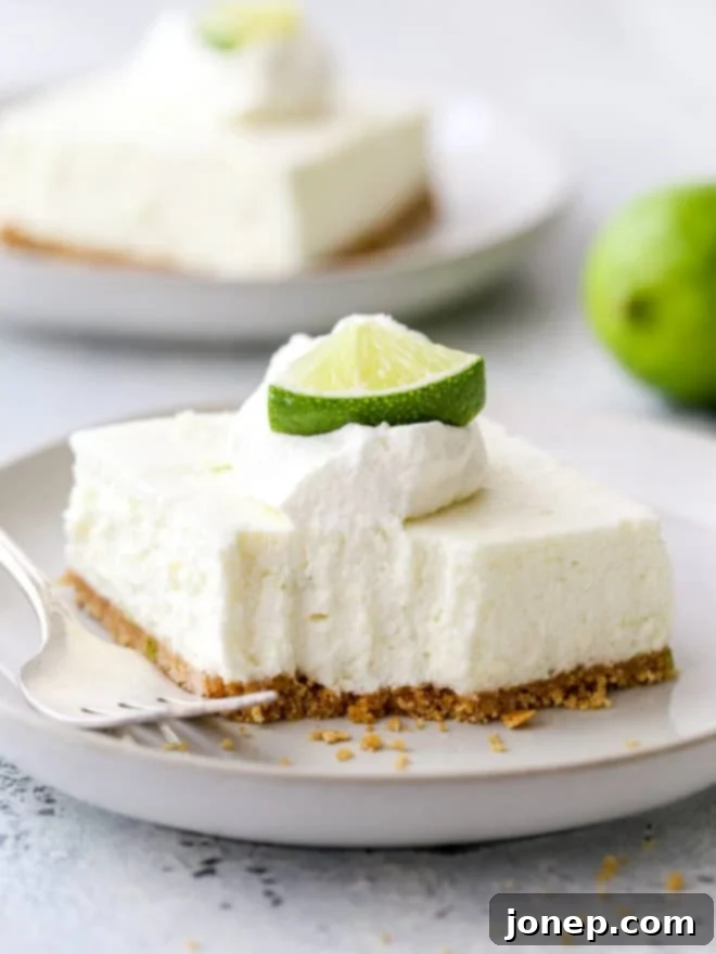 Key Lime No-Bake Cheesecake Bars 8 A lime cheesecake bar with a bite taken out, showing the creamy texture and graham cracker crust.