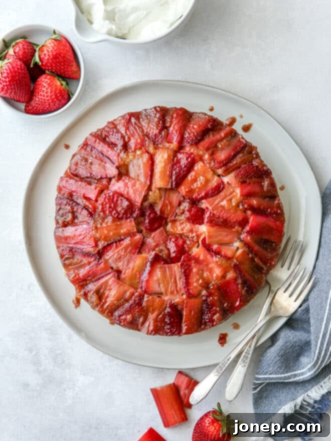 Strawberry Rhubarb Flip Cake 2 A slice of beautiful Strawberry Rhubarb Upside-Down Cake with fresh fruit on top, ready to be served.