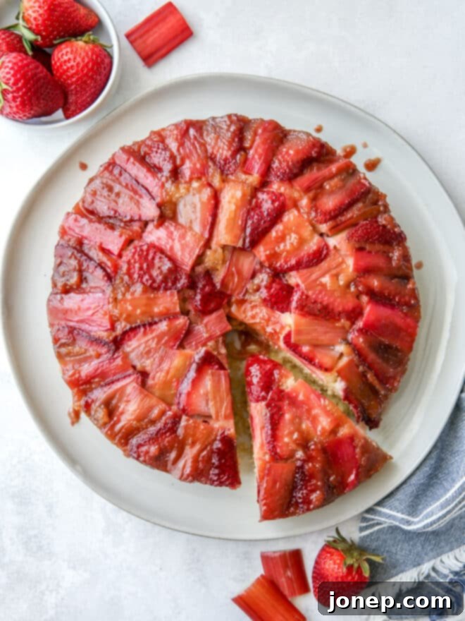 Strawberry Rhubarb Flip Cake 8 A beautifully presented whole Strawberry Rhubarb Upside-Down Cake on a serving plate.